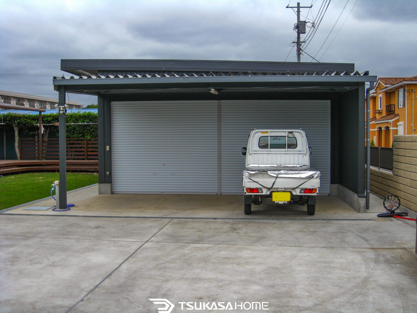千葉県船橋市のシャッター付き鉄骨ガレージとテラスを備えた施工事例

