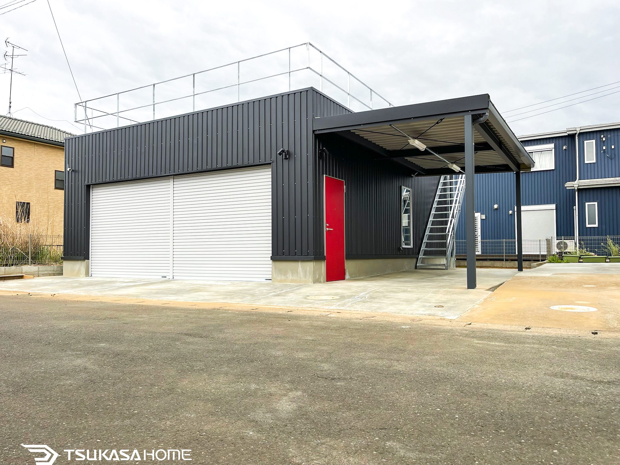 千葉県八街市で施工した黒い車庫ガレージ倉庫屋上テラス付でカーポート付の3台駐車+バイク1台駐車の外観画像