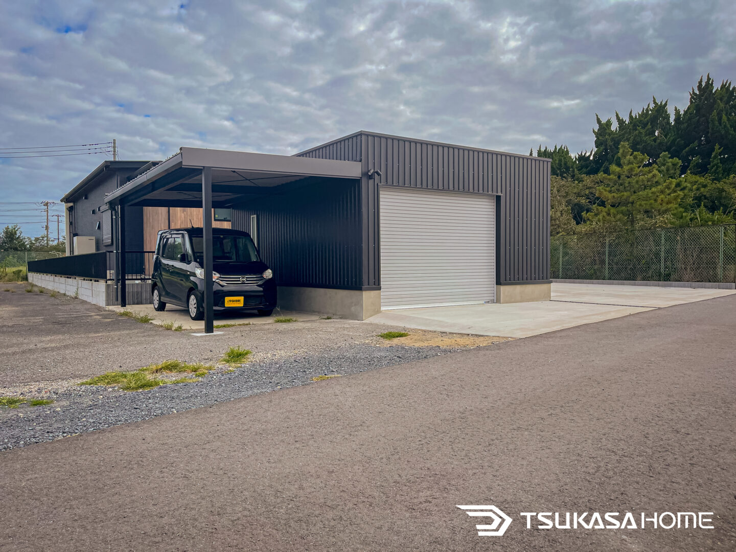 電動シャッター付きの2台駐車の黒い車庫ガレージ倉庫・カーポート付施工事例（神栖市）