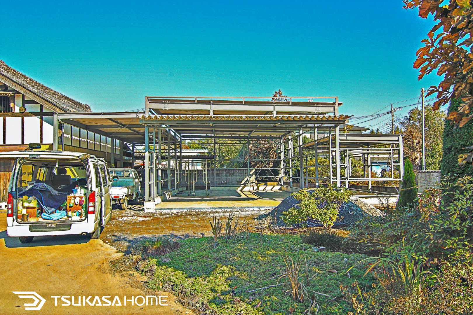 奥行きのある鉄骨ガレージ内部とシャッター方向の整備スペース(施工例)