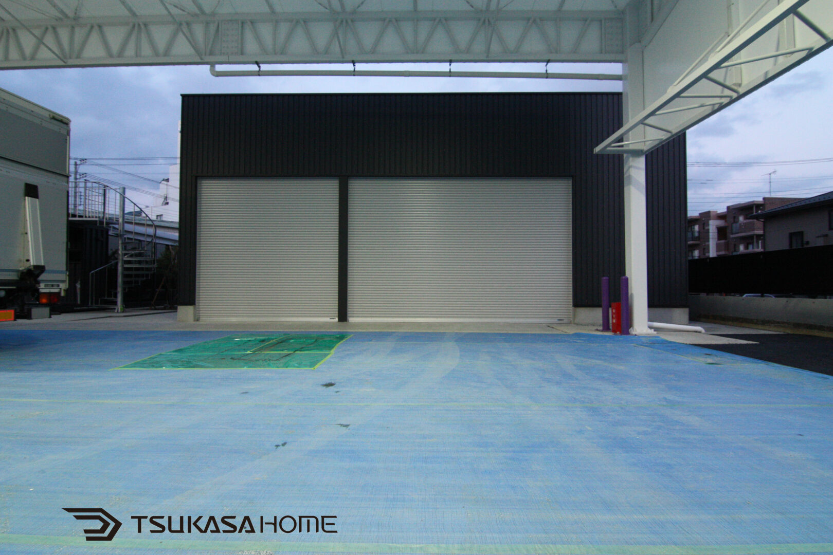 電動シャッター付の黒い大型倉庫外観正面画像　茨城県潮来市施工例