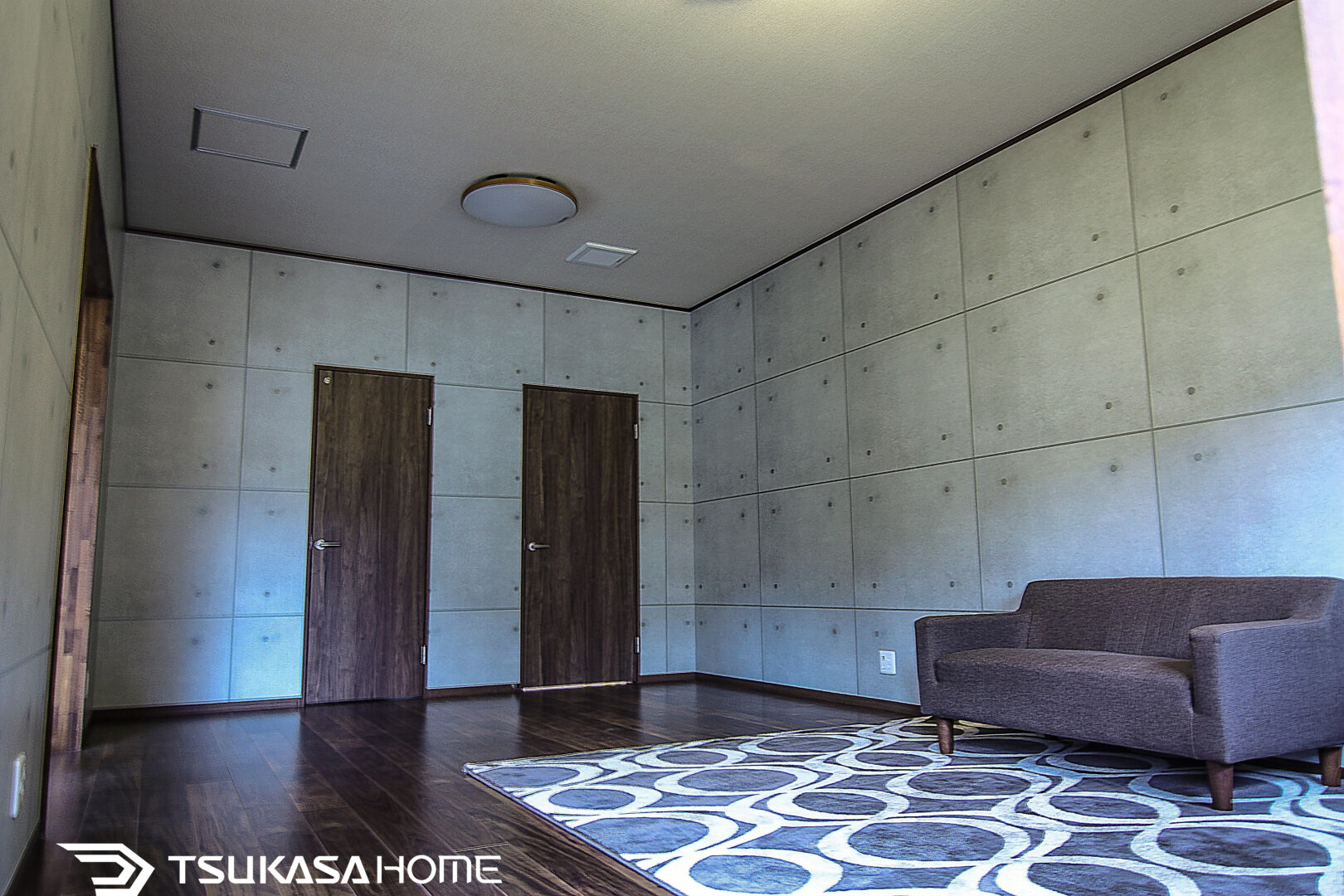 鉄骨倉庫をリフォームしたホビールーム｜コンクリート調壁とソファのある空間