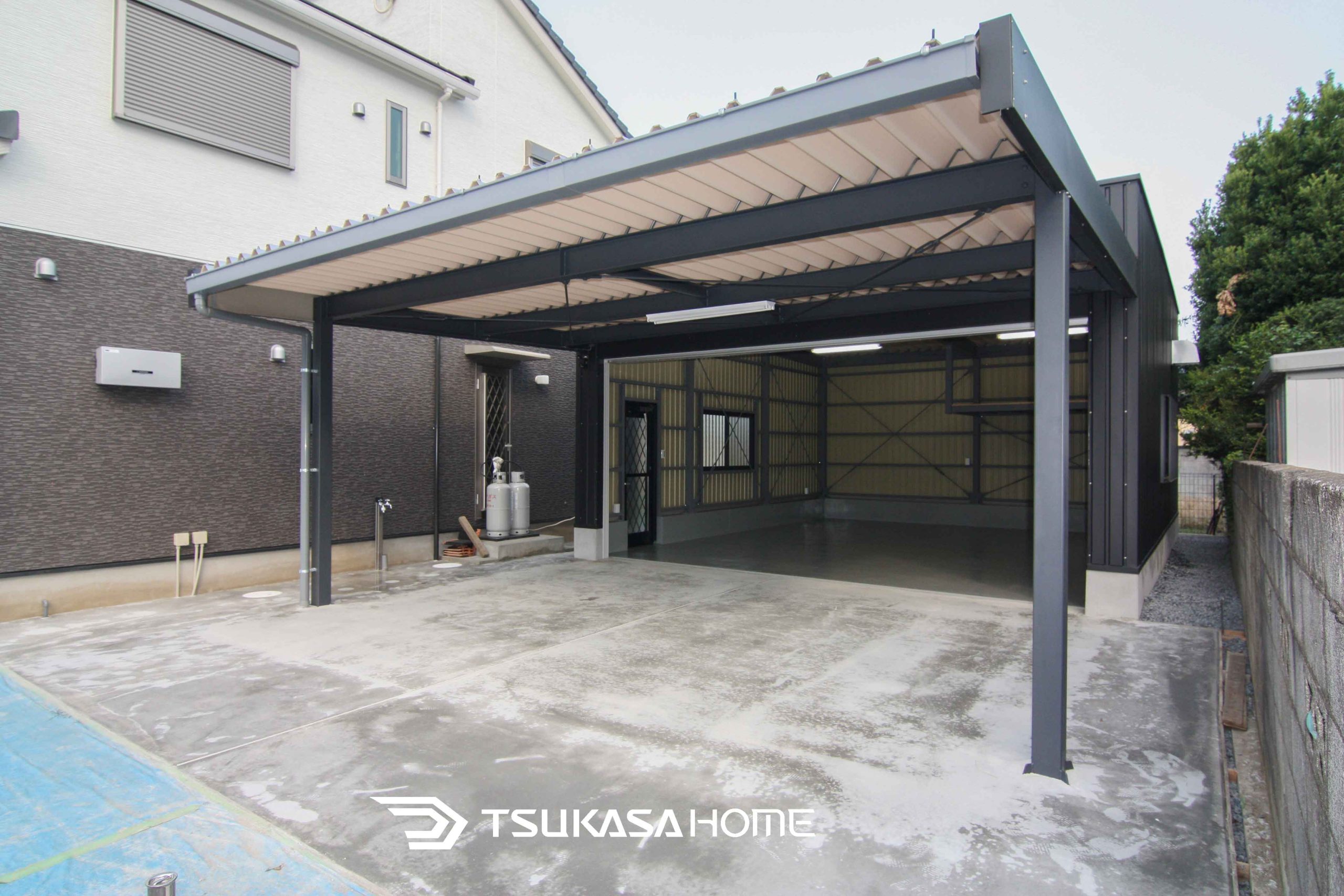 茨城県坂東市に建つおしゃれでかっこいい黒い4台駐車の車庫ガレージ倉庫にカーポートが付いた外観画像