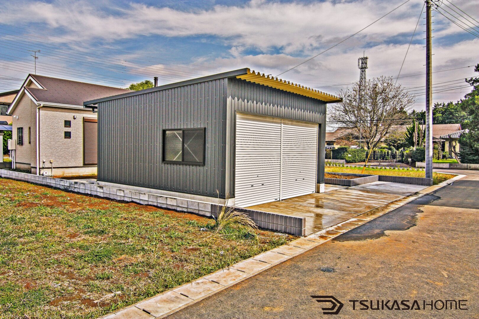 千葉県八街市で住宅隣に建築された鉄骨製2台駐車ガレージ。ブロック基礎とガルバリウム外壁仕様
