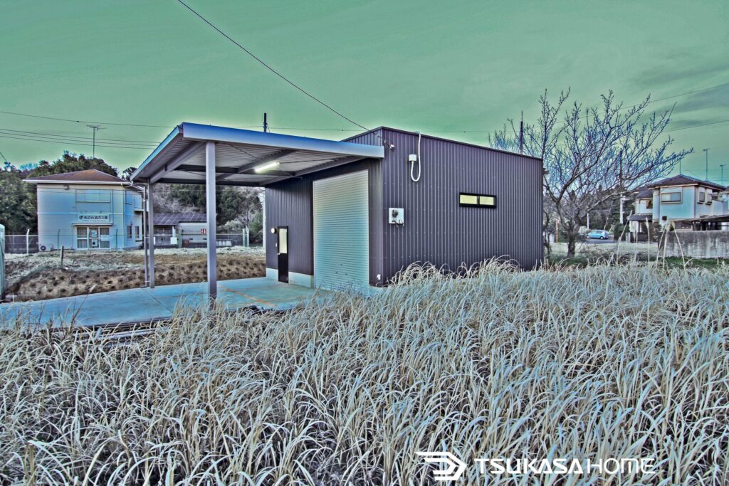 茨城県稲敷市で建築した3台駐車のホビールーム付き鉄骨ガレージ倉庫の外観写真。カーポート一体型デザイン