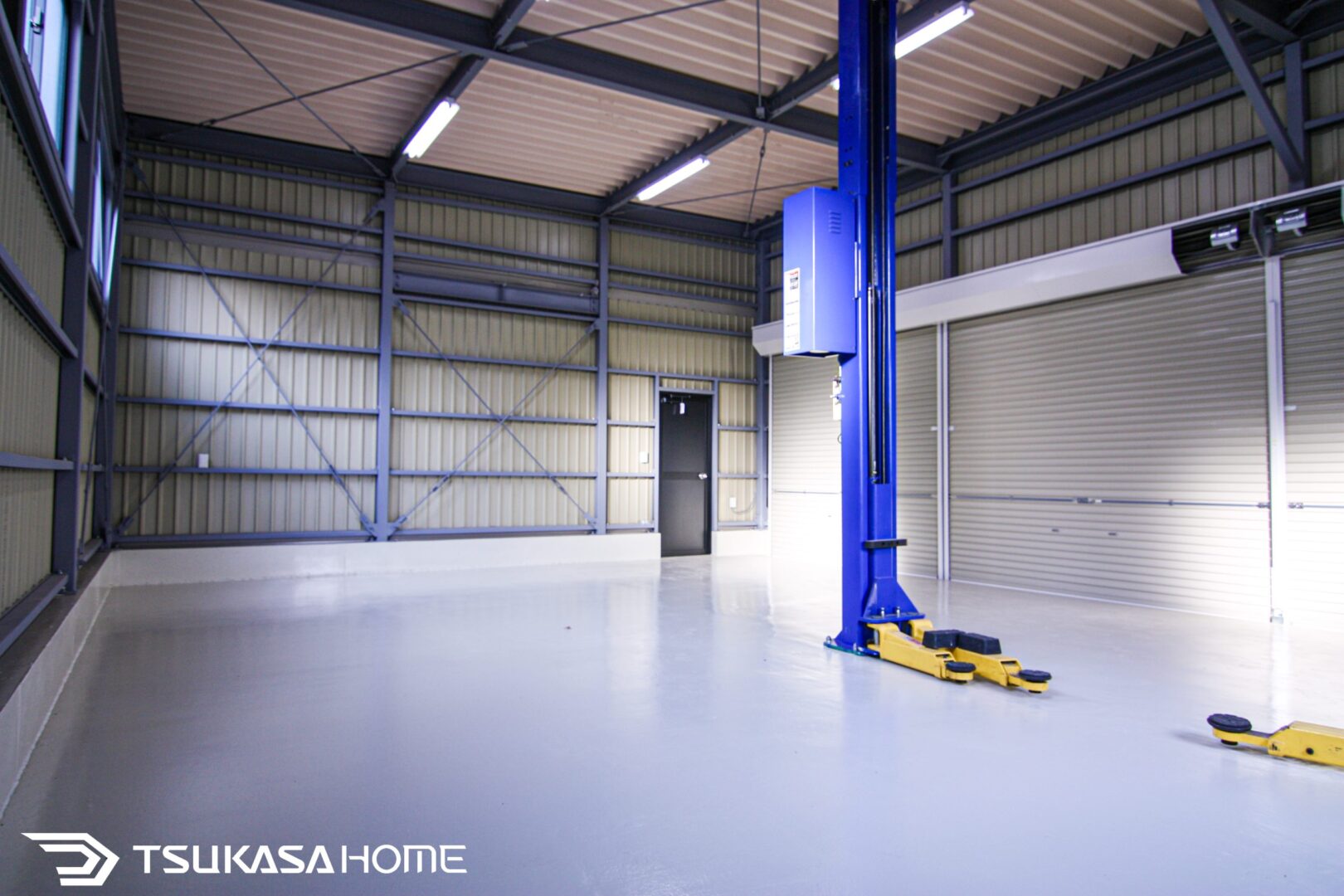 車用2柱リフトを備えた鉄骨ガレージの内観。整備やメンテナンス作業ができる本格仕様
