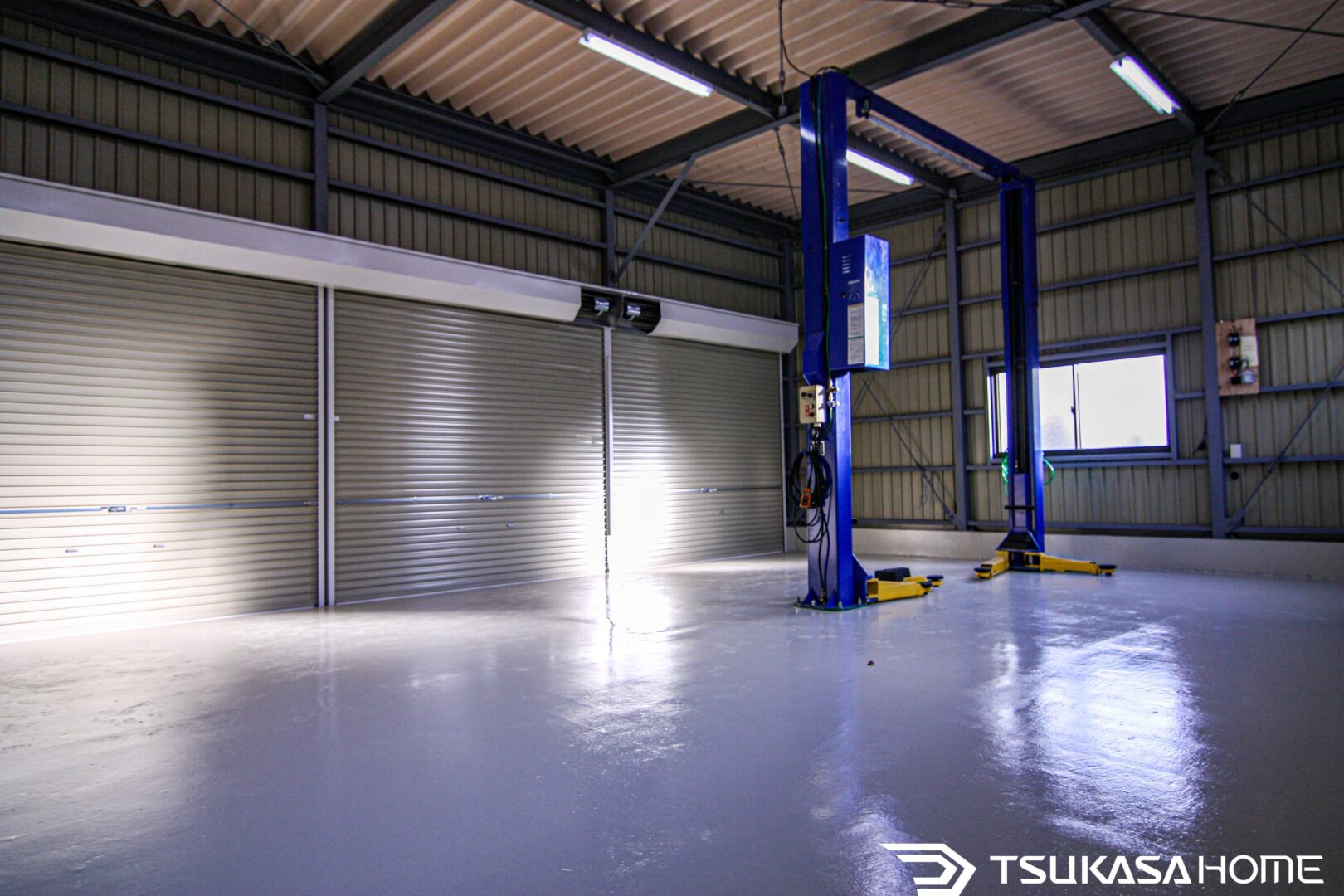 鉄骨ガレージ内部のシャッター3連画像。広い床面と高い天井で作業スペースも十分
