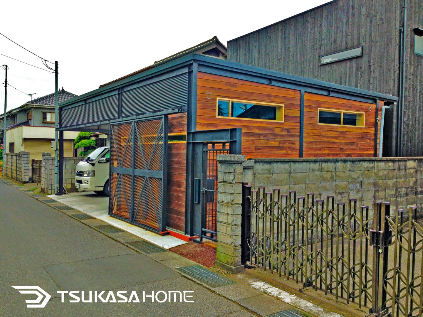 千葉県匝瑳市に建てられた鉄骨ガレージ事務所。木目調サイディングがアクセントとなった外観デザイン。