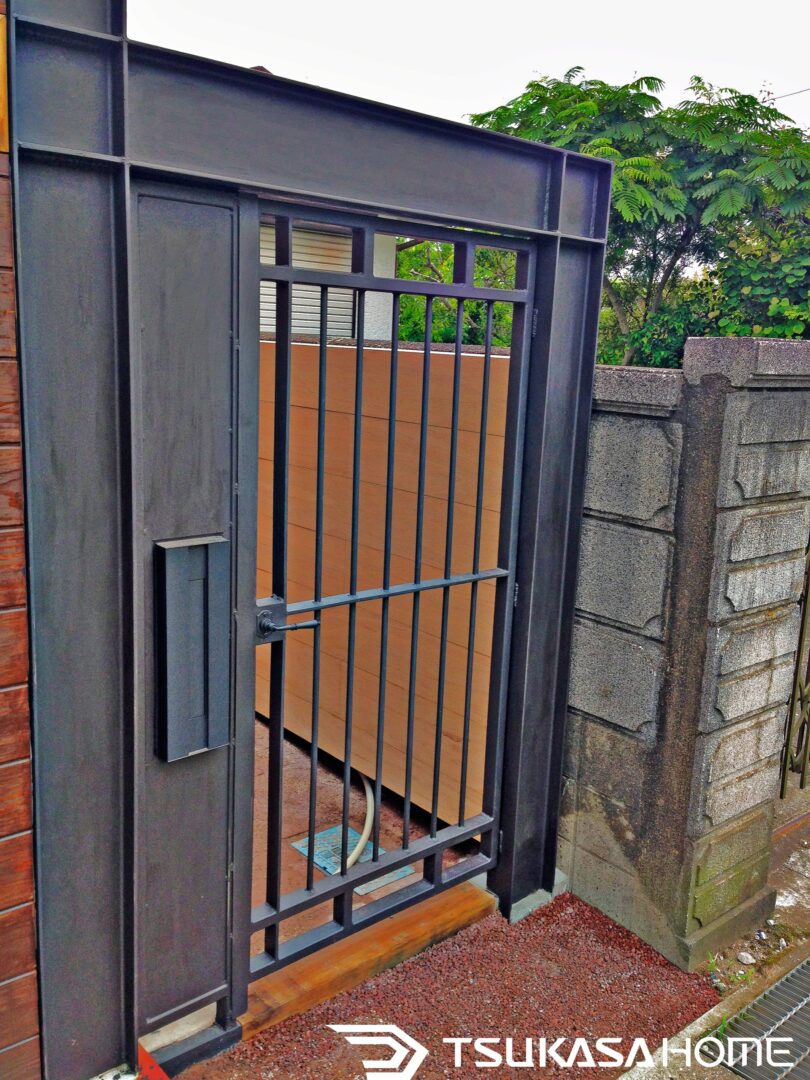 千葉県匝瑳市で建築された鉄骨ガレージ事務所。木目サイディングと鉄骨フレームの質感が際立つエントランスデザイン。