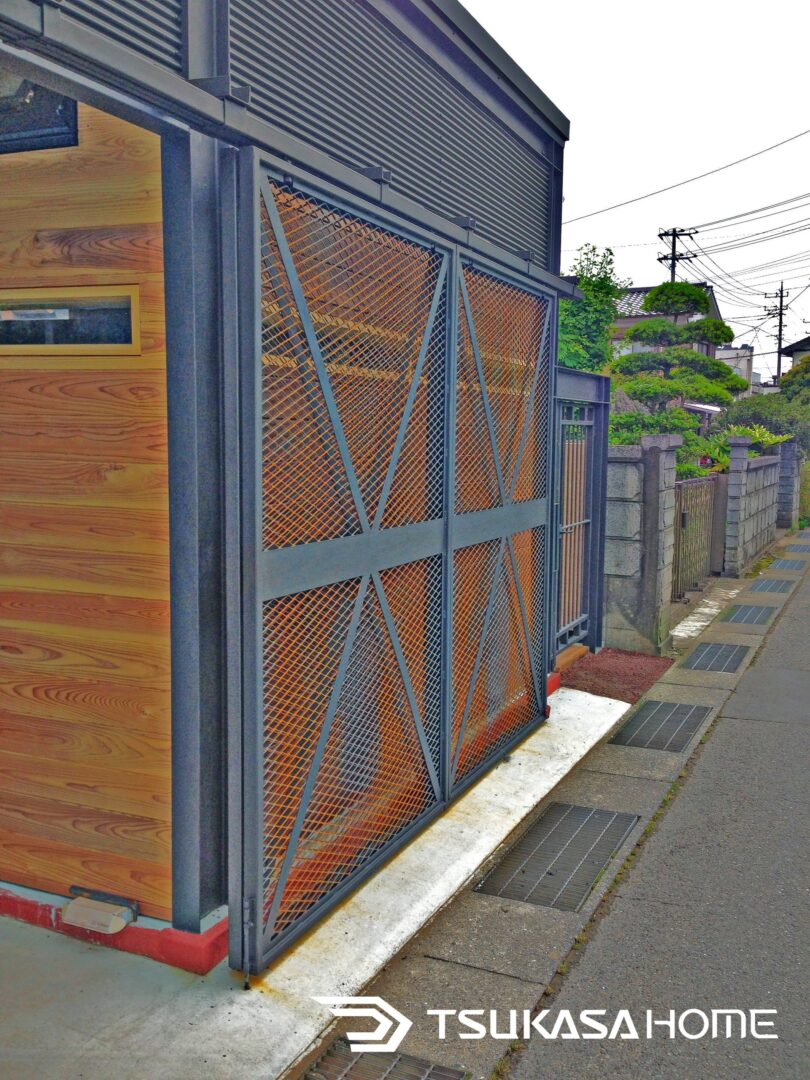 千葉県匝瑳市の鉄骨カーポート兼事務所ガレージ。スチールフレームとメッシュゲートで防犯対策を強化。