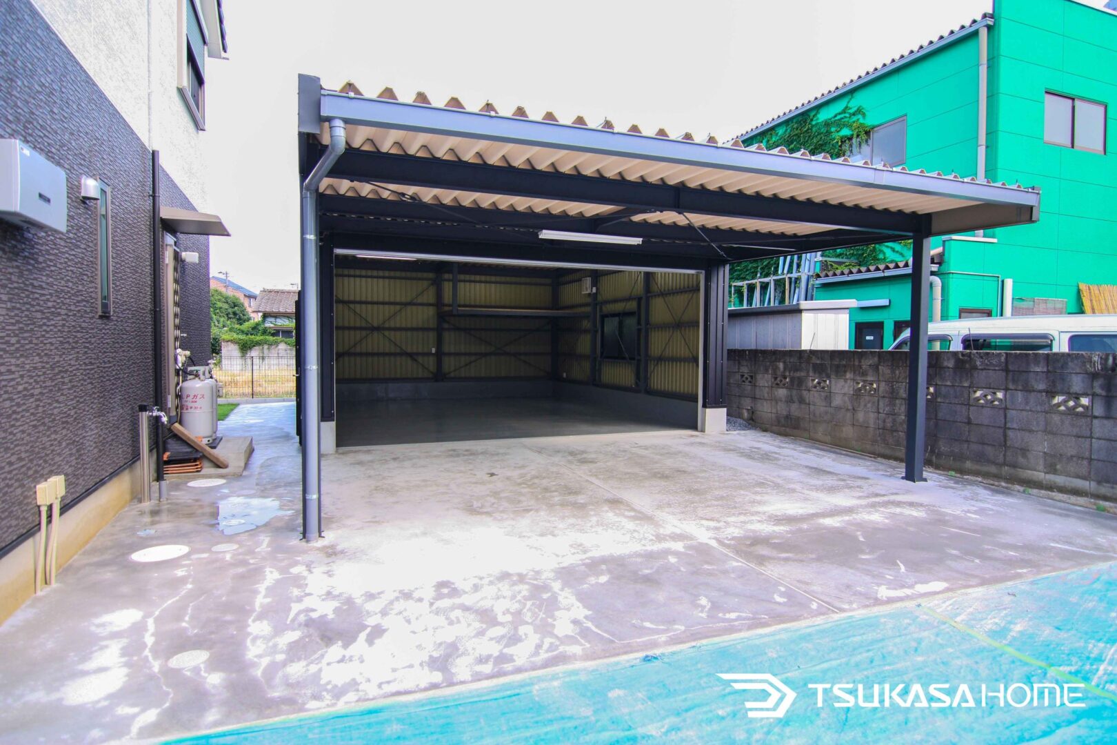 茨城県坂東市に施工された2台駐車可能な片側開放型鉄骨ガレージ。開放性と機能性を両立した外観。