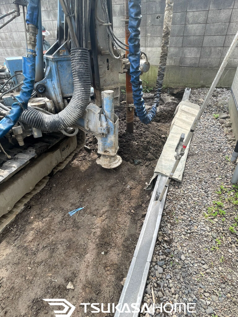 柱状改良工法で地盤を掘削し固化材を混ぜながら支持層へ杭を形成する施工状況
